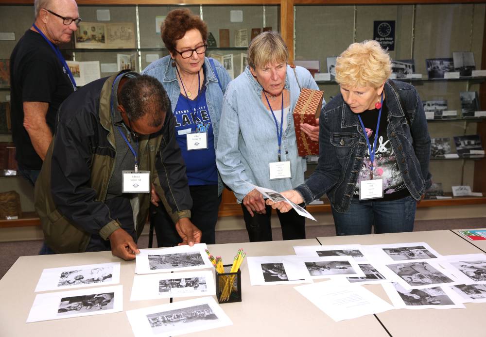 Class of 1968 looking at photos from when they were students.